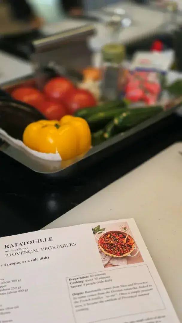 A tray of ratatouille vegetables next to the recipe