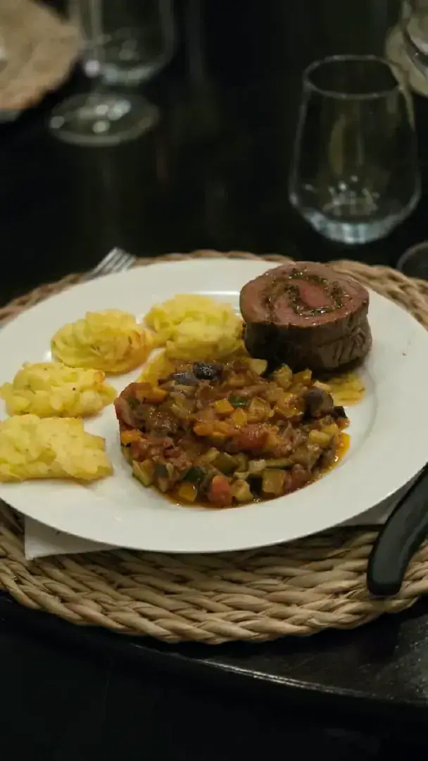 Stuffed beef fillet with duchess potatoes on a white plate